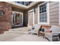 Inviting front porch featuring brick accents and comfortable seating, perfect for enjoying the outdoors at 11725 Montgomery Cir, Longmont, CO 80504