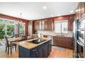 Gourmet kitchen featuring an island cooktop, granite countertops, stainless steel appliances, and a breakfast nook at 11725 Montgomery Cir, Longmont, CO 80504