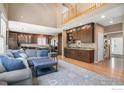 Bright open-concept living area features a wet bar, hardwood floors, and large windows at 11725 Montgomery Cir, Longmont, CO 80504