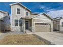 Charming two-story home featuring a two-car garage and stone accents, creating a welcoming curb appeal at 13 Chipeta Way, Lochbuie, CO 80603