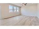 Bright living room with hardwood floors, recessed lighting, and large windows, creating an inviting atmosphere at 13 Chipeta Way, Lochbuie, CO 80603