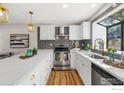 Well-lit kitchen featuring white cabinets, stainless steel appliances, quartz countertops, and modern fixtures at 18234 E Arizona Ave # D, Aurora, CO 80017