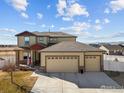 Charming home boasts a three-car garage, stone accents, and a well-maintained lawn for curb appeal at 2100 Cadman St, Berthoud, CO 80513