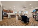 Open-concept living area showcasing a kitchen island, stone fireplace, and ample natural light at 2100 Cadman St, Berthoud, CO 80513