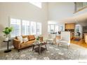 Open-concept living room features large windows, comfortable seating, and seamless transition to the kitchen at 2107 Pintail Dr, Longmont, CO 80504