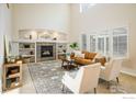 Bright living room with a fireplace, built-in shelves, and large windows with shutters at 2107 Pintail Dr, Longmont, CO 80504