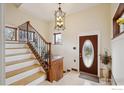 Elegant entryway with a decorative staircase, an ornate chandelier, and a stained-glass front door at 211 E Geneseo St, Lafayette, CO 80026