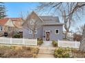 Charming gray home with a red door and a white picket fence, creating curb appeal at 211 E Geneseo St, Lafayette, CO 80026