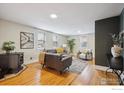 Bright living room with hardwood floors, stylish furniture, and abundant natural light from multiple windows at 211 E Geneseo St, Lafayette, CO 80026
