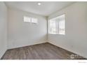 Bright bedroom featuring wood-look floors, fresh paint, and natural light from a window at 286 Chardon Ave, Brighton, CO 80601