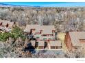 Aerial view of a townhome with mature trees and a view of mountains in the distance at 3104 Bell Dr, Boulder, CO 80301