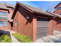 Attached one-car garage with brown door complements the property's exterior with a well-manicured garden at 3104 Bell Dr, Boulder, CO 80301