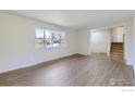 Bright living room featuring wood-look floors, a large window, and neutral paint, creating a spacious atmosphere at 4288 Graham Ct, Boulder, CO 80305