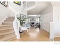 Bright entryway with a curved staircase, hardwood floors, and a glimpse of the living room at 4860 Fountain St, Boulder, CO 80304