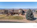 Attractive home with mountain views, a well-maintained lawn, and an inviting circular driveway at 8023 Dawnhill Cir, Erie, CO 80516