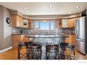 Modern kitchen featuring stainless steel appliances, a unique island with seating, and hardwood floors at 8023 Dawnhill Cir, Erie, CO 80516