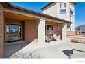 Welcoming covered porch with seating area, brick accents, and a stylish front door at 8023 Dawnhill Cir, Erie, CO 80516