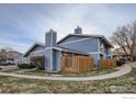 A view of home's exterior and fenced-in patio surrounded by well-manicured lawns at 8483 Everett Way # A, Arvada, CO 80005