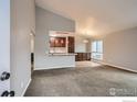 Open floor plan reveals living space with vaulted ceiling open to kitchen and dining area at 8483 Everett Way # A, Arvada, CO 80005