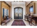 Elegant entryway with decorative iron doors, sophisticated decor, and marble flooring create a grand entrance at 8845 Crimson Clover Ln, Longmont, CO 80503