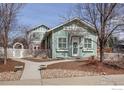 Charming sage-green home with well-maintained landscaping and inviting walkway to the front door at 954 11Th Ave, Longmont, CO 80501