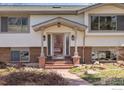 Inviting front porch with brick accents and a decorative glass front door at 1120 Green Cir, Boulder, CO 80305