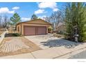 Home features a two-car garage, spacious driveway, and mature trees at 140 Judson St, Longmont, CO 80501