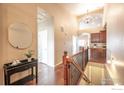 Elegant entryway featuring hardwood floors, a chandelier, and staircase leading to the lower level at 2317 Winding Dr, Longmont, CO 80504