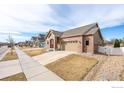 Well-maintained single-Gathering home featuring a brick facade, attached garage, and landscaped front yard at 2317 Winding Dr, Longmont, CO 80504