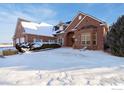 Charming brick home featuring a unique arched doorway and picturesque snow covered front yard at 2366 Shoreside Dr, Berthoud, CO 80513