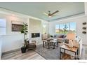 Bright living room with a cozy fireplace, ceiling fan, neutral tones, and ample natural light through large windows at 2723 Crystal Springs Ln, Longmont, CO 80503
