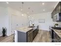 Modern kitchen featuring gray cabinets, a large granite island, and stainless steel appliances at 2729 Bear Springs Cir, Longmont, CO 80503
