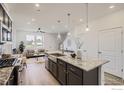 Bright, open floor plan with modern kitchen, granite island, stainless appliances and adjacent living area at 2729 Bear Springs Cir, Longmont, CO 80503
