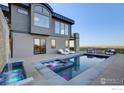Backyard pool with a waterfall feature, lounge chairs, and beautiful mountain views at 3645 Cholla Ct, Boulder, CO 80304
