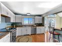 Well-lit kitchen with white cabinets, stainless steel appliances, and a view of the outside at 3885 Telluride Pl, Boulder, CO 80305
