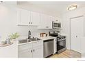 Modern kitchen features stainless steel appliances, white cabinetry, and sleek countertops at 390 Owl Dr, Louisville, CO 80027
