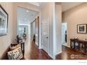 Spacious hallway with hardwood floors, white trim, and a view leading to the living area at 4420 White Rock Dr, Broomfield, CO 80023