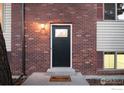 Inviting front entrance with brick facade, dark door, a well-lit porch and a key-themed welcome mat at 4652 Hampshire St, Boulder, CO 80301