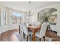 Open dining room featuring hardwood floors, chandelier, and archway to living area at 520 Campo Way, Superior, CO 80027