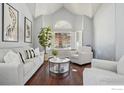 Bright living room with hardwood floors, white furniture, and large window at 520 Campo Way, Superior, CO 80027