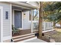 Inviting covered front porch featuring bench seating, wood decking, and classic trim at 554 W Spruce Way, Louisville, CO 80027