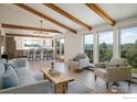 Bright open-plan living space with wooden beams and floor-to-ceiling windows offering mountain views at 67 S Peak Rd, Boulder, CO 80302