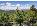Scenic mountain view showcasing snow-capped peaks and lush forests from the balcony railing at 67 S Peak Rd, Boulder, CO 80302