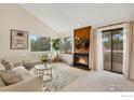 Bright living room featuring a fireplace with wood paneling and access to the outside patio at 6877 Countryside Ln # 277, Niwot, CO 80503