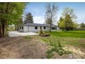 Exterior backyard featuring a patio area and mature trees at 10587 N 95Th St, Longmont, CO 80501