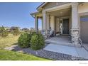 Inviting front porch with stone accents and well-placed landscaping at 12886 Clearview St, Firestone, CO 80504