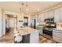 Modern kitchen featuring stainless steel appliances and an oversized island at 12886 Clearview St, Firestone, CO 80504