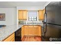 Well-lit kitchen showcasing granite countertops, wooden cabinetry, and sleek, modern appliances at 1405 Broadway # 101, Boulder, CO 80302