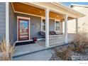 Inviting front porch with seating area, perfect for relaxing and enjoying the outdoors at 1451 Moonlight Dr, Longmont, CO 80504