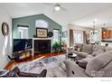 Bright living room features a vaulted ceiling, fireplace, and hardwood floors at 1451 Moonlight Dr, Longmont, CO 80504